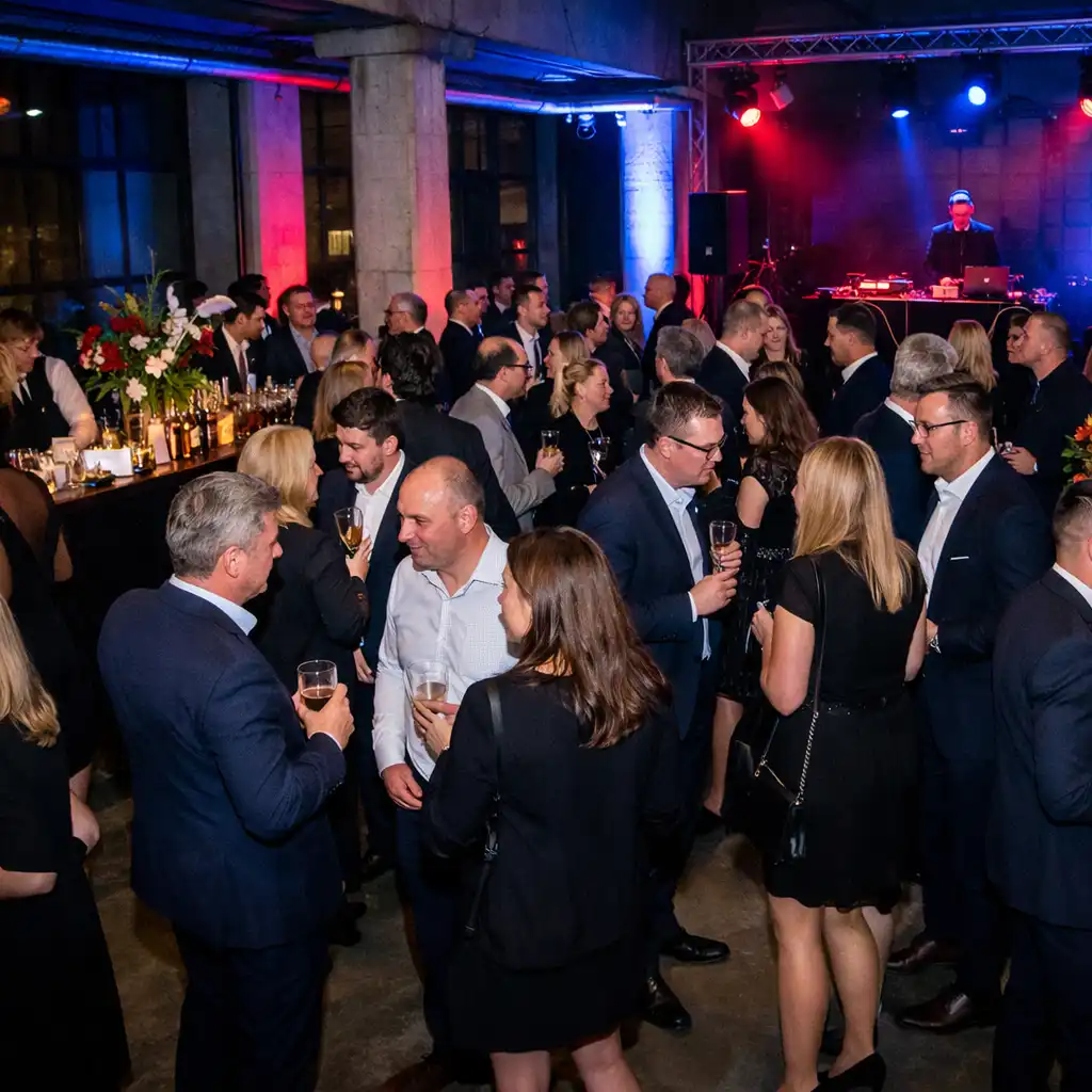 Hosté na nočním networkingovém eventu v industriálním prostoru